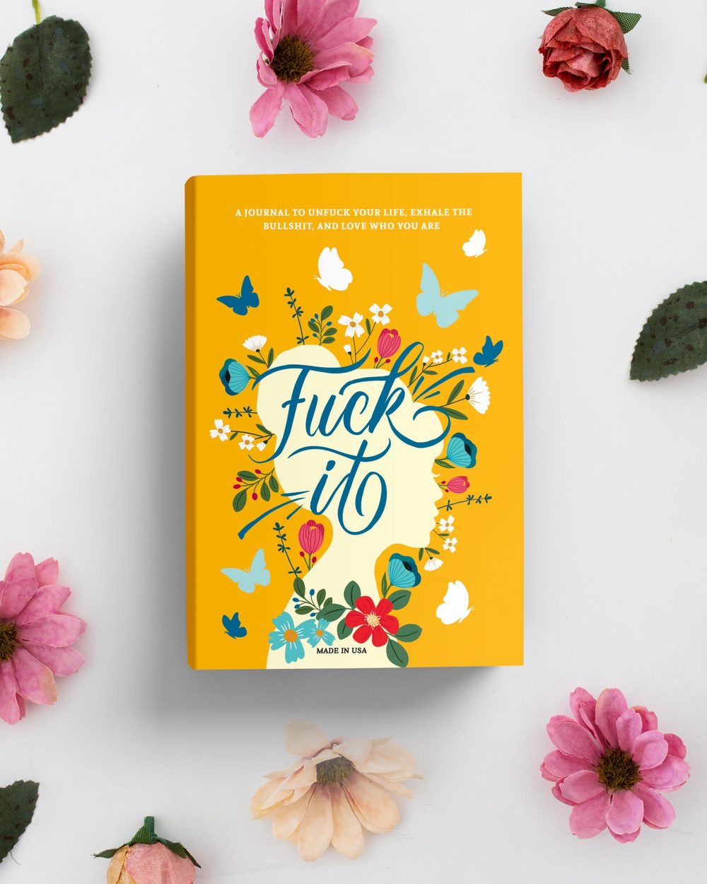 Fuck It journal among pink and peach flowers