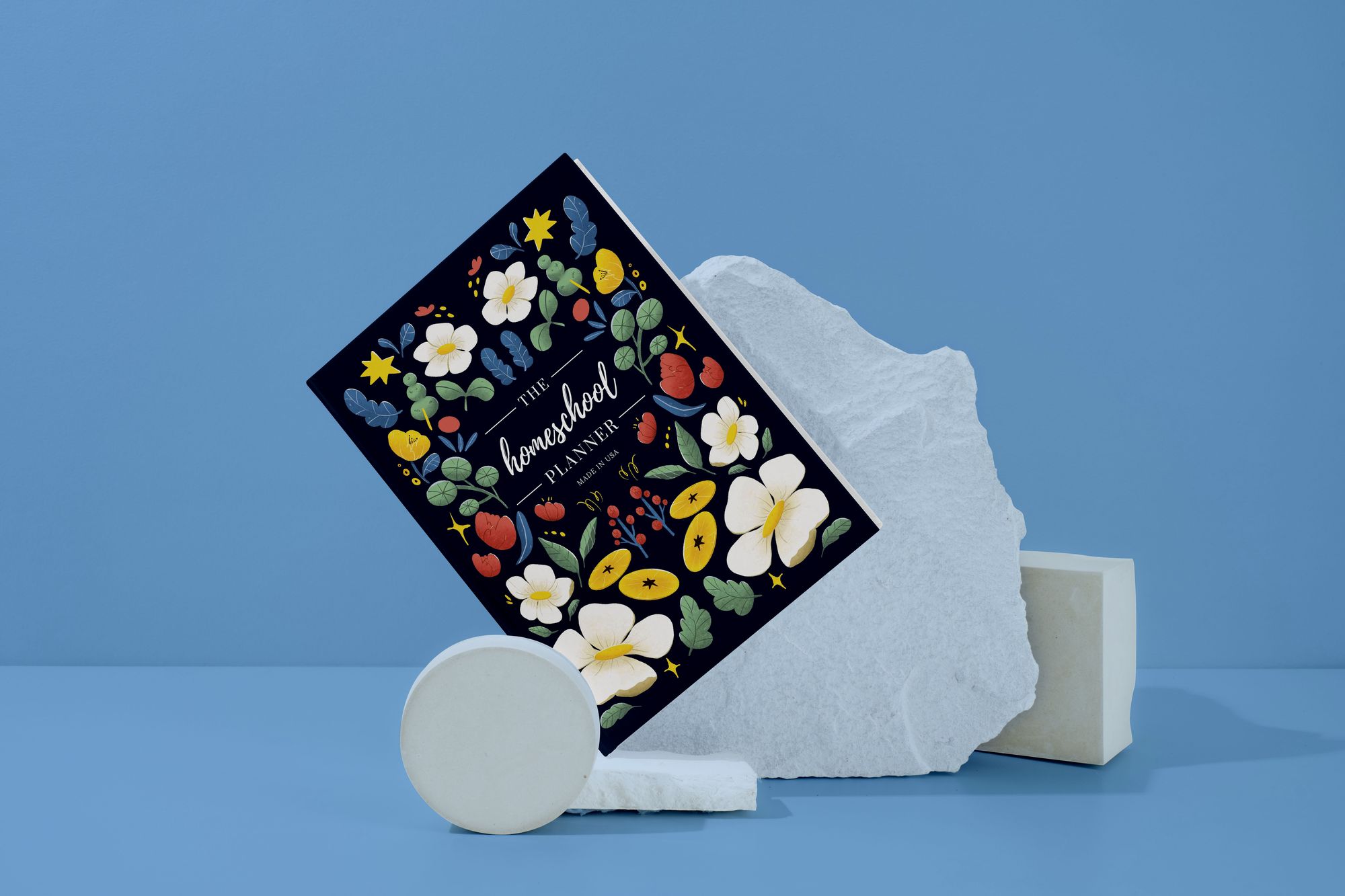 The Homeschool Planner styled on a blue backdrop